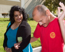 Caregiver helps guide person served on a walk