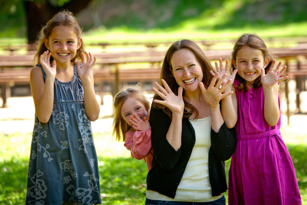 Mom does jazz hands with three daughters