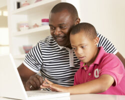 Father and Down Syndrome son with laptop