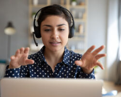 Young female Service Provider at her laptop while she engages in a presentation