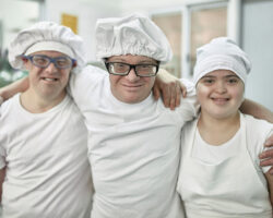 three individuals served by regional centers at work together in a bakery