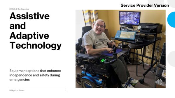 Assistive and Adaptive Technology “A smiling man in a blue power wheelchair uses a mounted adaptive communication device and computer monitor in a room.”